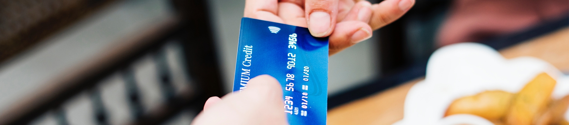 A women handing over a debit card A women handing over a debit card