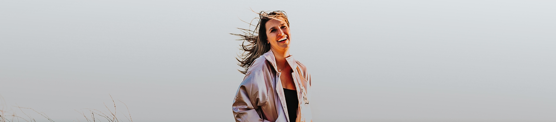 A women laughing with her hair blowing in the wind A women laughing with her hair blowing in the wind