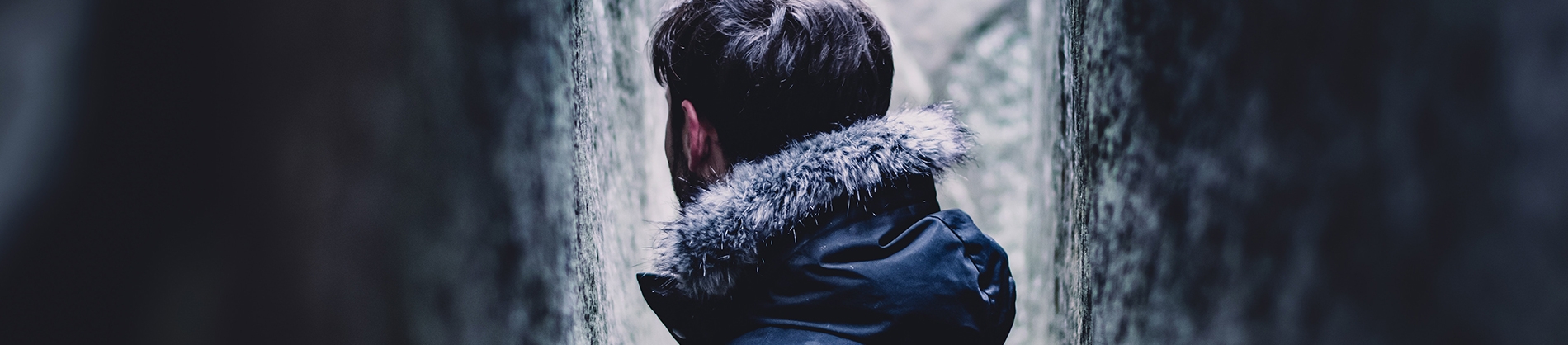 A man stood between two walls looking away A man stood between two walls looking away