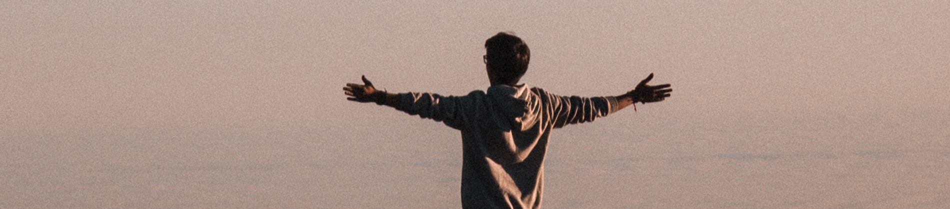 A man in a hoodie with his arm stretched out wide A man in a hoodie with his arm stretched out wide