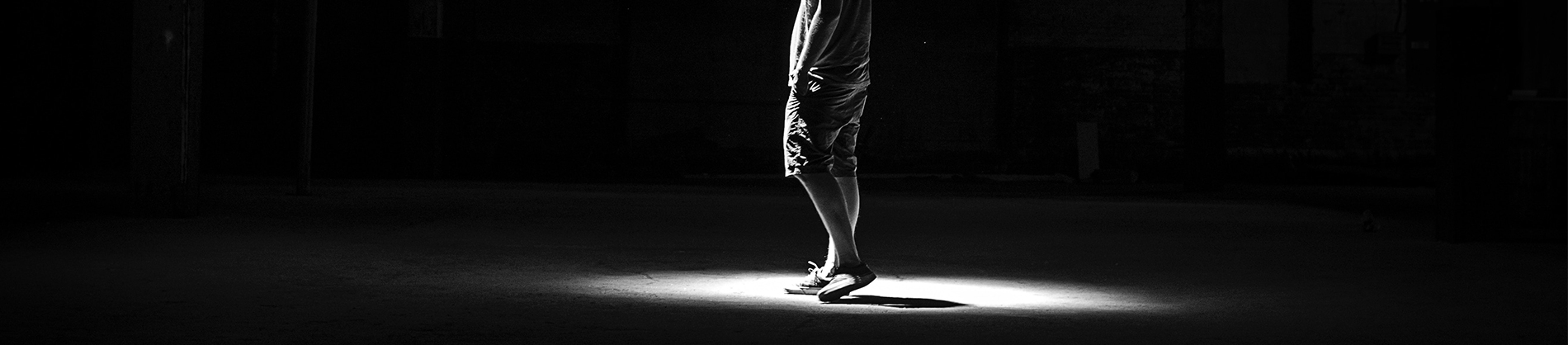 black and white photo of a man stood in a spotlight black and white photo of a man stood in a spotlight