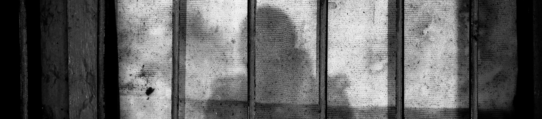 A shadow of a person on ion bars A shadow of a person on ion bars