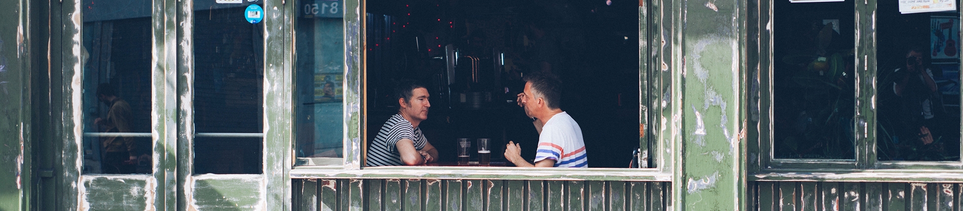 Two men sat in a pub talking Two men sat in a pub talking