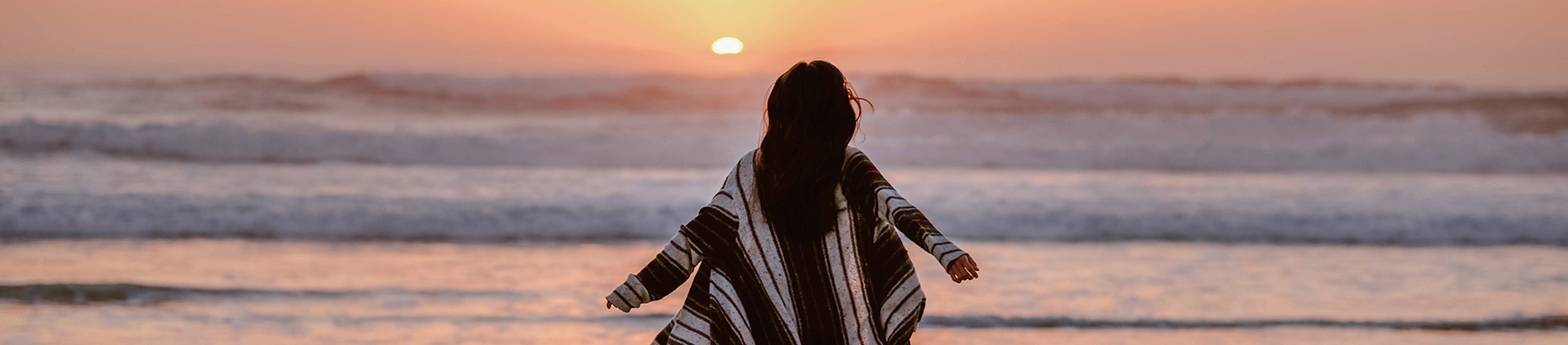 A women running towards the sea and sunset A women running towards the sea and sunset