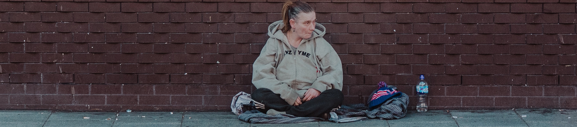 A homeless women sat by a brick wall A homeless women sat by a brick wall
