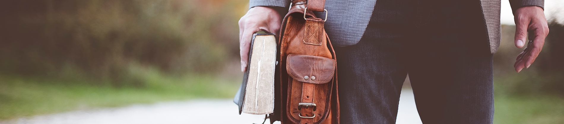 A man with a satchel holding his bible A man with a satchel holding his bible