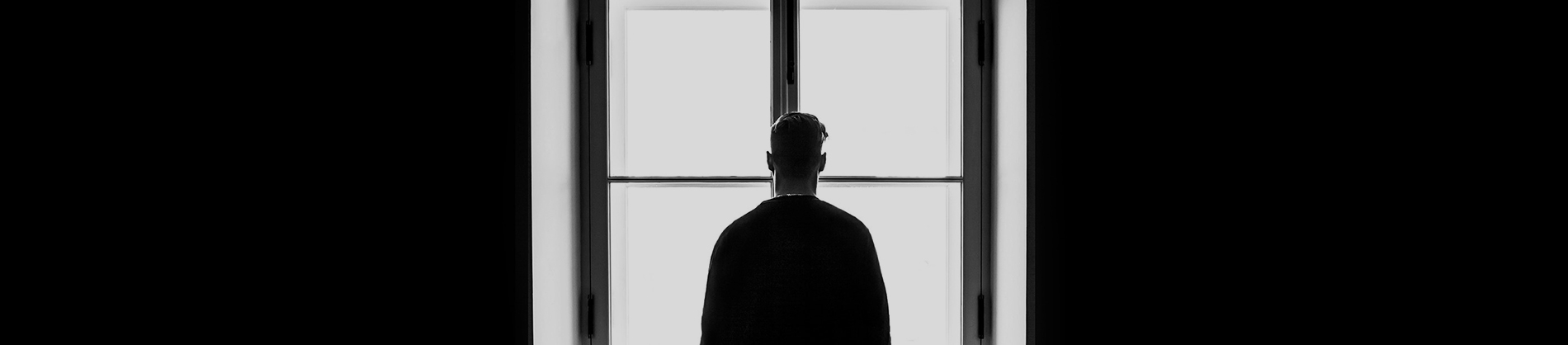 A man looking out of a long window A man looking out of a long window