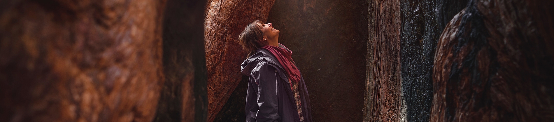A smiling women in a cave looking up A smiling women in a cave looking up
