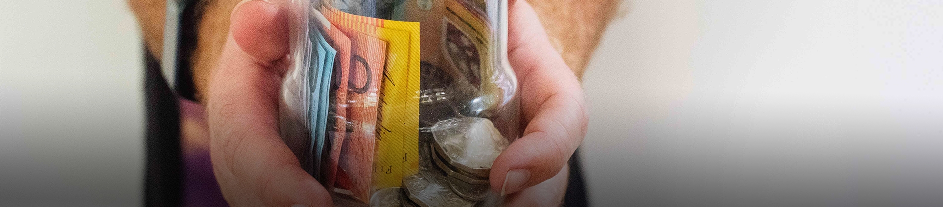 A man holding a jar of money A man holding a jar of money