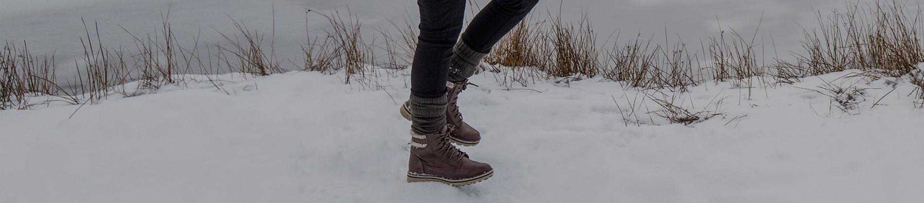 Girl walking in boots through snow