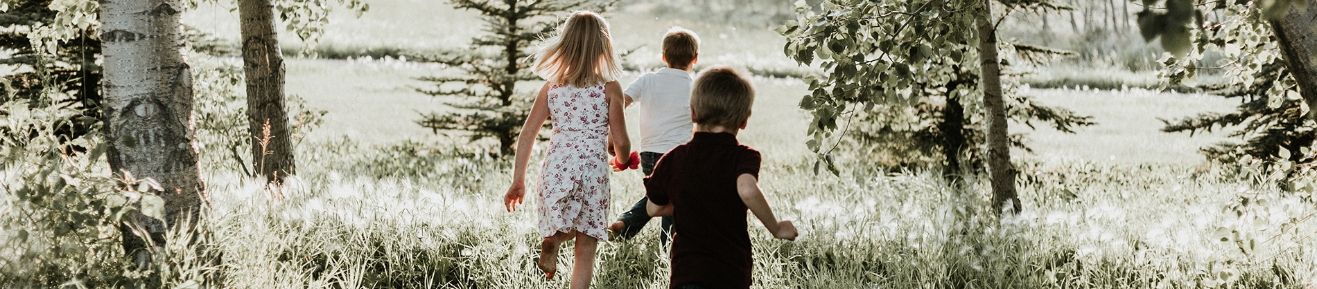 Three children running through a sunny forest Three children running through a sunny forest