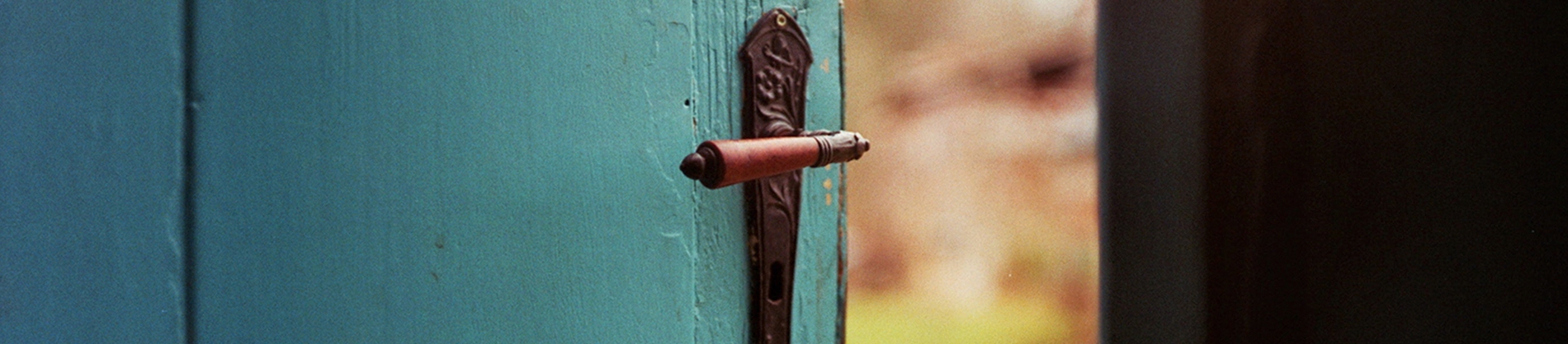 A blue wooden door slightly ajar A blue wooden door slightly ajar