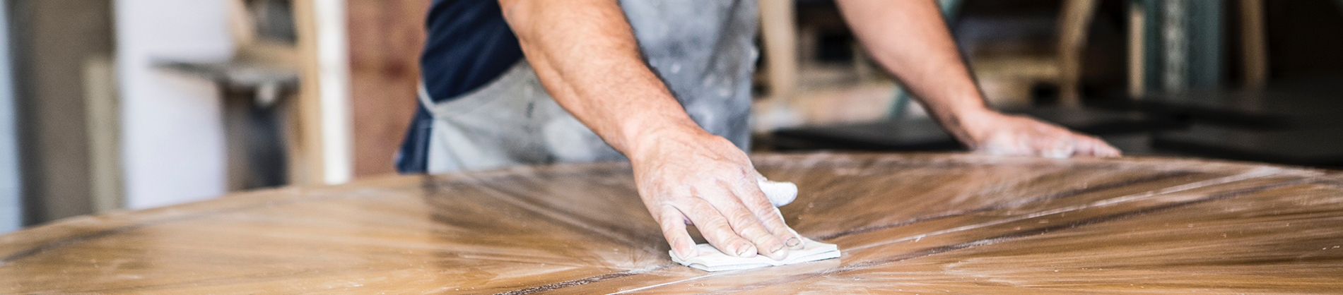 A man sanding down a wooden table