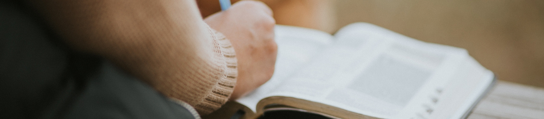 A women writing in her open bible