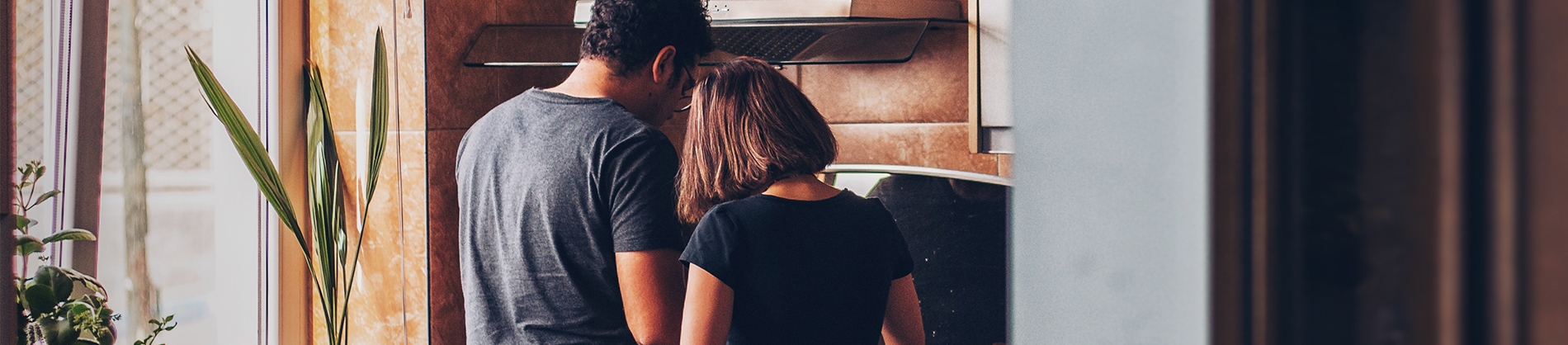 A couple in their kitchen cooking together A couple in their kitchen cooking together