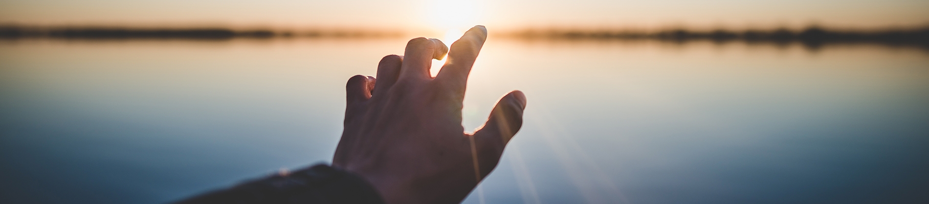 A man reaching out his hand towards the sunlight A man reaching out his hand towards the sunlight