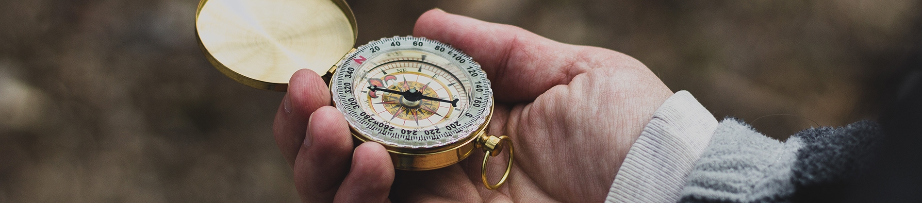 A person holding a compass out in front of her A person holding a compass out in front of her