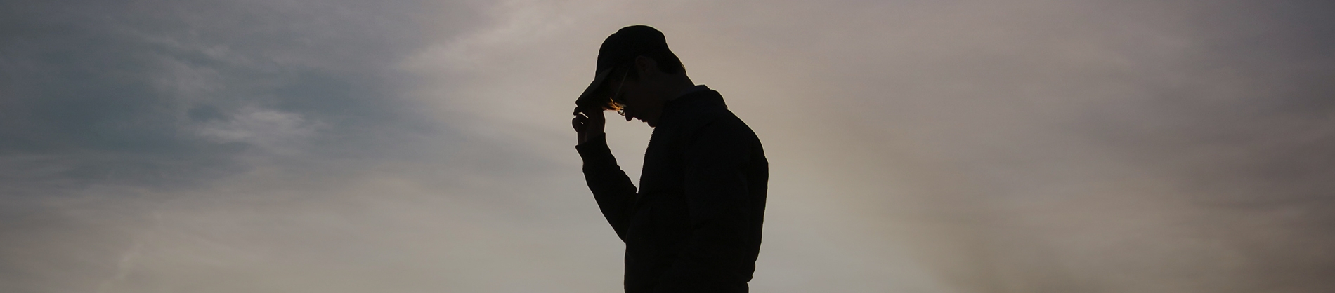 A silhouette of a man wearing a cap A silhouette of a man wearing a cap