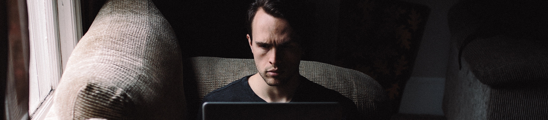 A man sat on his sofa using a laptop A man sat on his sofa using a laptop