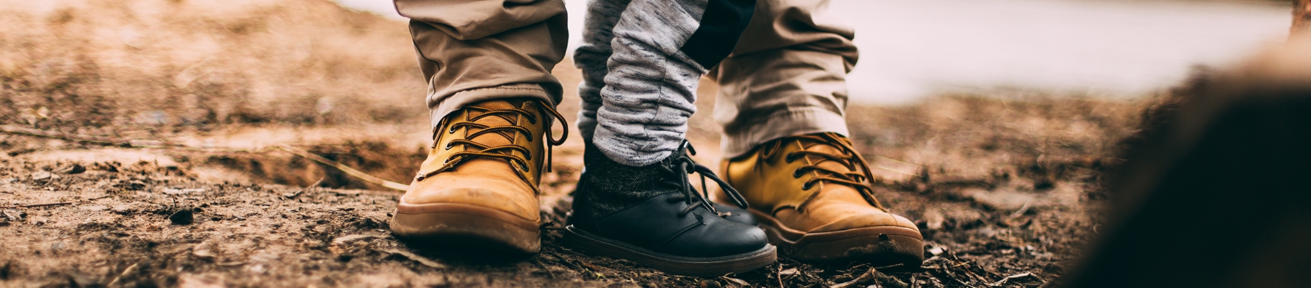 A father and small child stood together in walking boots A father and small child stood together in walking boots