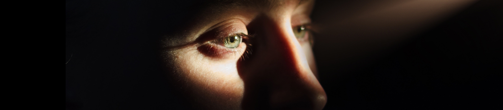 Light shining onto a mans face, lighting up his eyes Light shining onto a mans face, lighting up his eyes