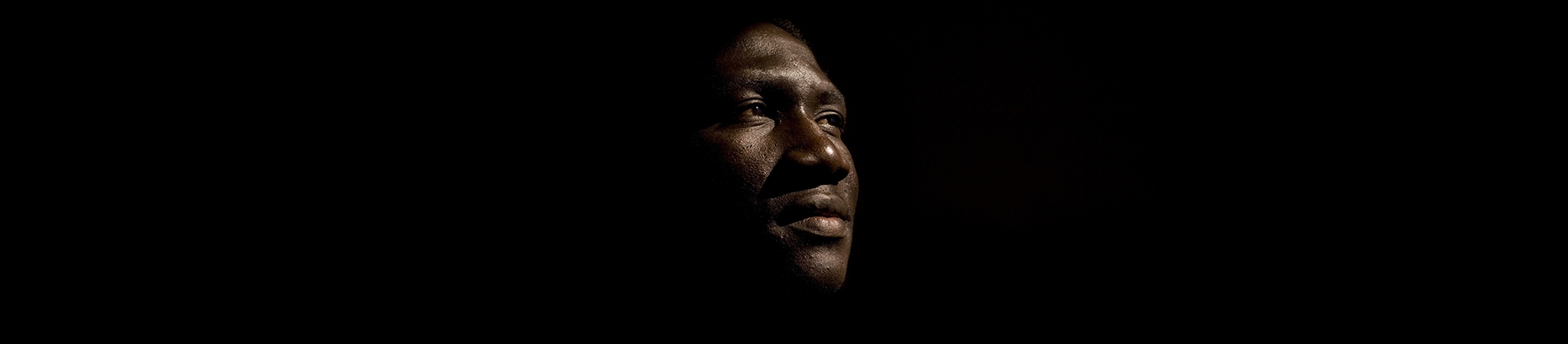A man in the dark with his face half lit A man in the dark with his face half lit