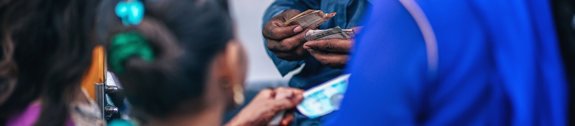 A man sorting out money and a women handing over money A man sorting out money and a women handing over money