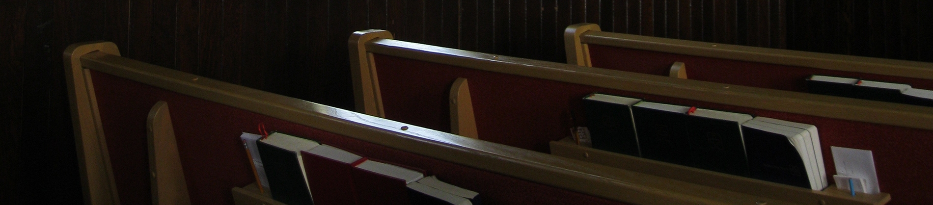 Church pews with bibles stacked in the shelf Church pews with bibles stacked in the shelf