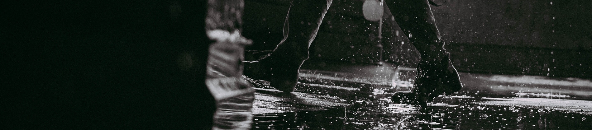 A man walking through puddles in the rain A man walking through puddles in the rain