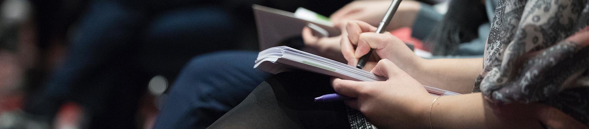 People sat in a meeting taking notes