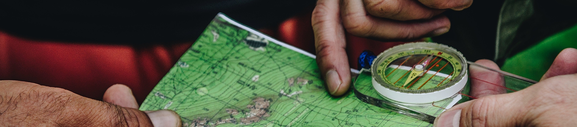 Two people looking at a map and compass Two people looking at a map and compass