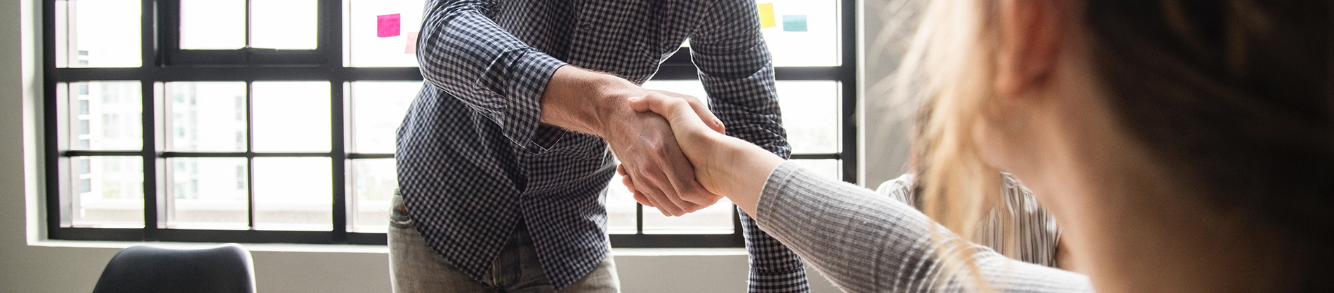 A man shaking a women's hand in a office A man shaking a women's hand in a office