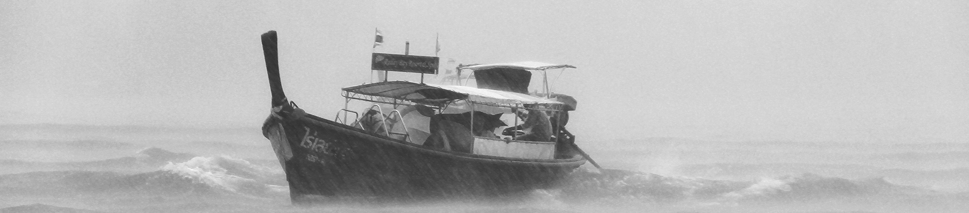 A black and white photo of a boat in the middle of a storm A black and white photo of a boat in the middle of a storm