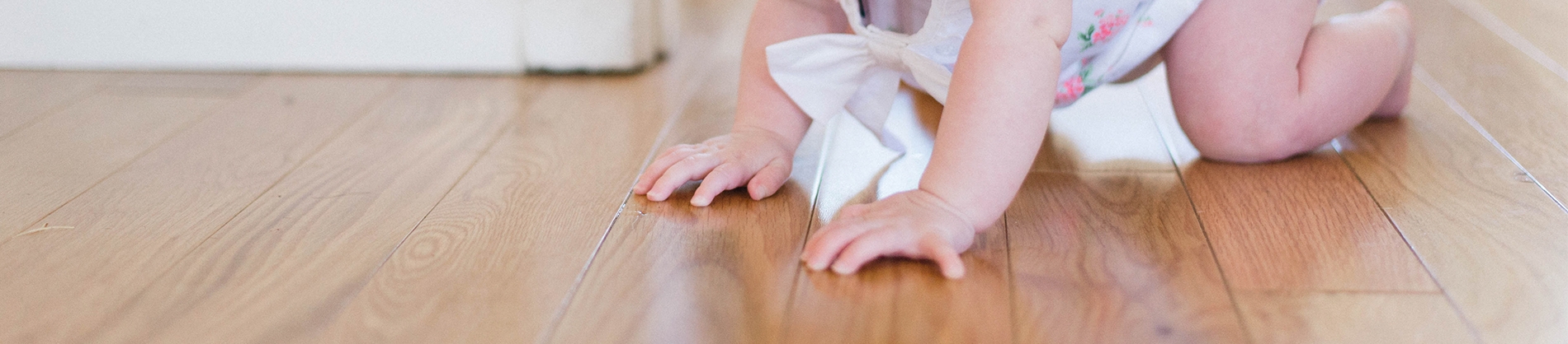 Baby crawling on a wooden floor