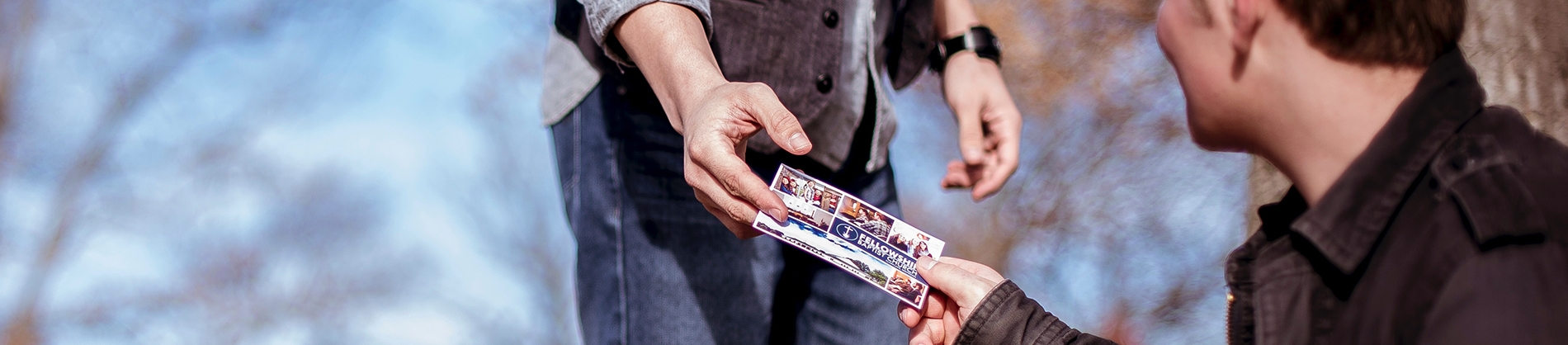 A man handing a friend a church flyer A man handing a friend a church flyer
