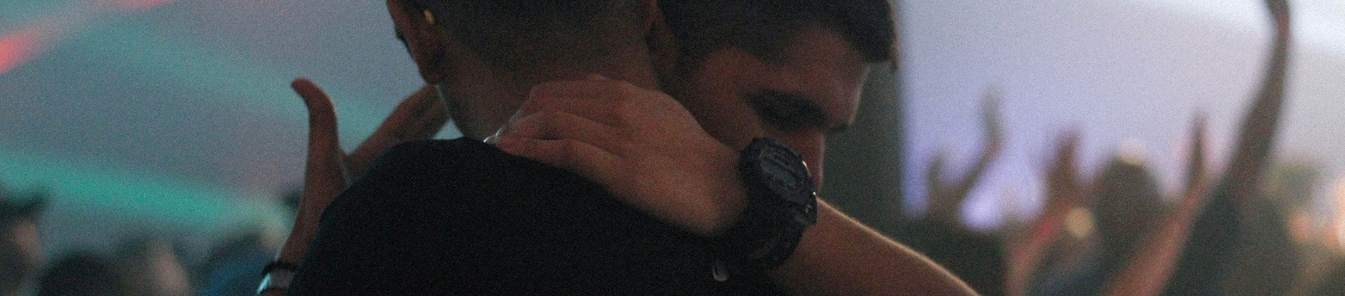 A man crying while being hugged by a friend in a church