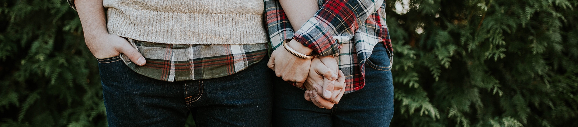 A couple in checked shirts holding hands A couple in checked shirts holding hands
