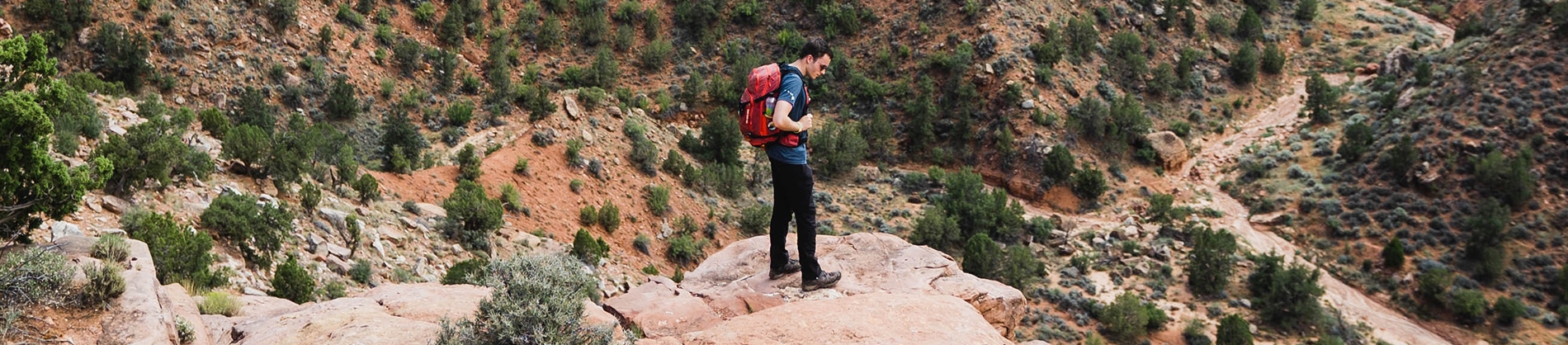 A man stood on a cliff looking over rocks A man stood on a cliff looking over rocks