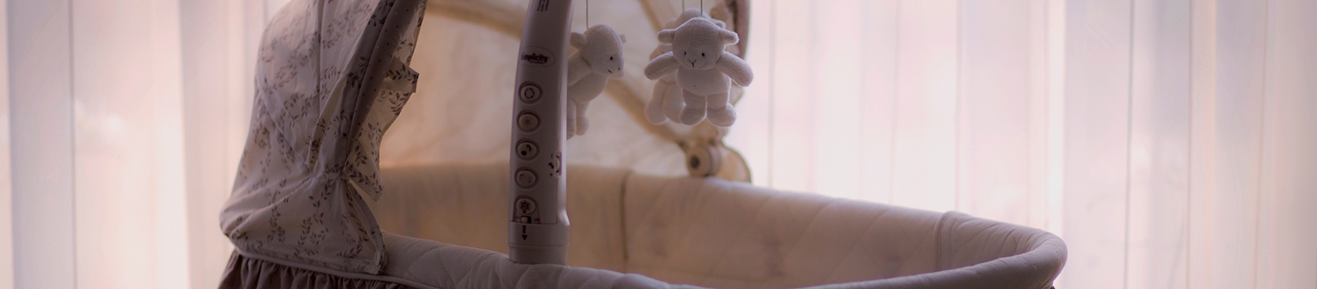 Empty cot with a bear mobile above Empty cot with a bear mobile above