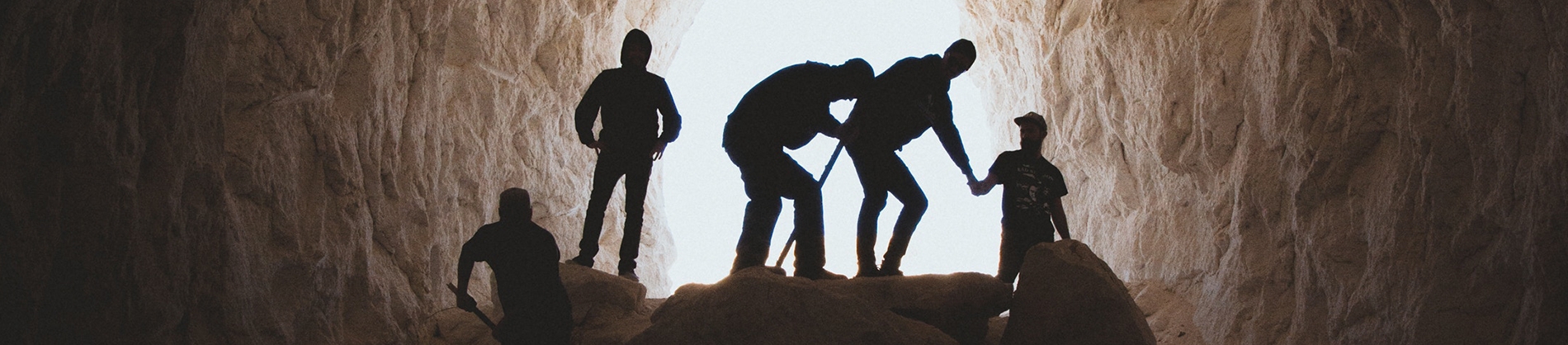 A group of men digging inside of a cave A group of men digging inside of a cave