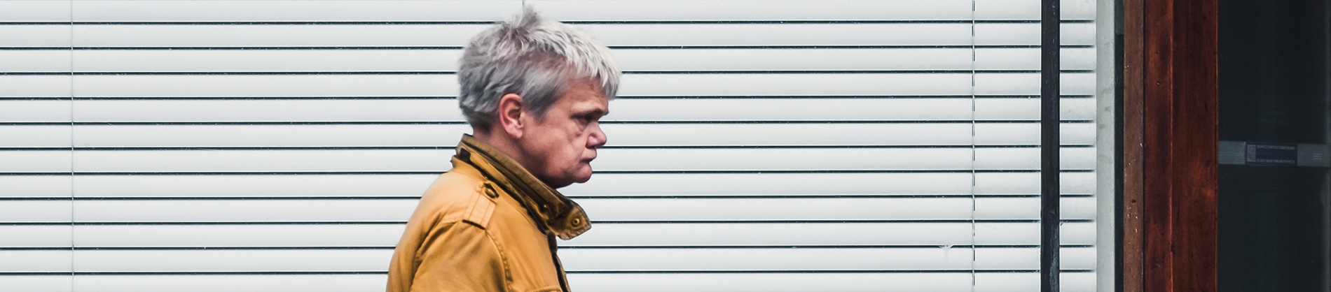 A man looking angry walking along a road A man looking angry walking along a road