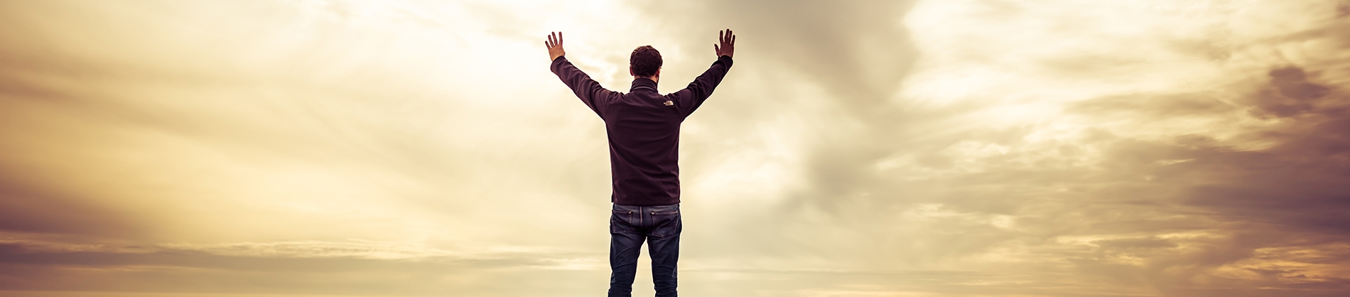 A man with his arms up in praise towards the sky A man with his arms up in praise towards the sky