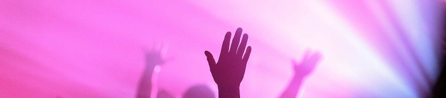 Hands in the air with bright pink lights shining Hands in the air with bright pink lights shining