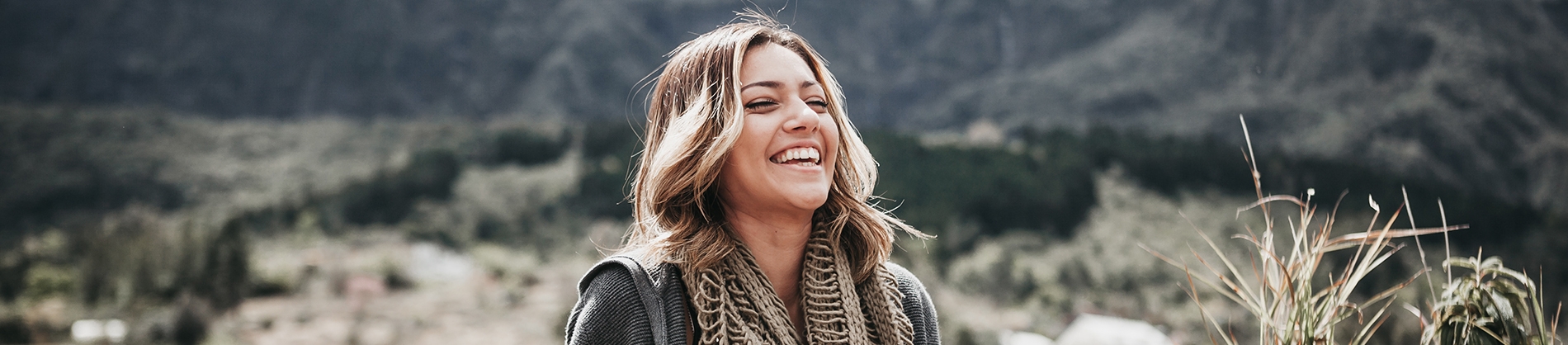 A women laughing with fields behind her A women laughing with fields behind her