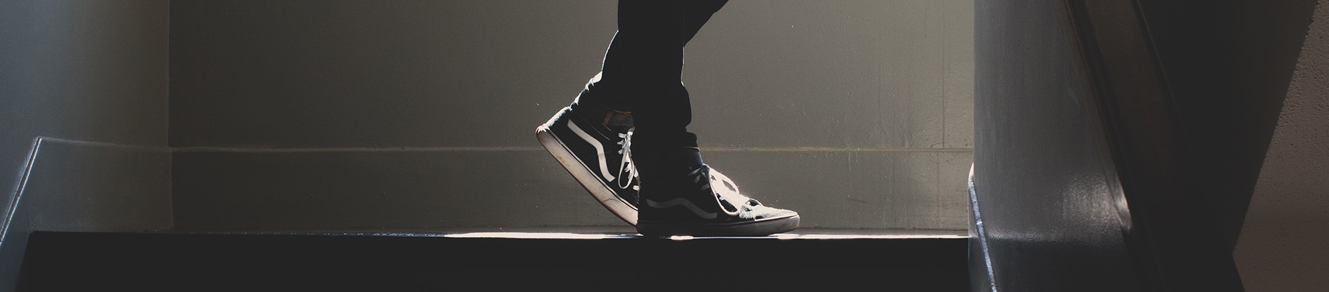 A guy walking up the stairs in black and white trainers A guy walking up the stairs in black and white trainers