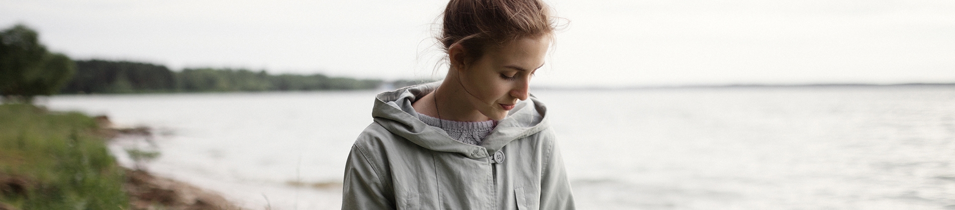 A women walking along beside a river looking towards the ground A women walking along beside a river looking towards the ground