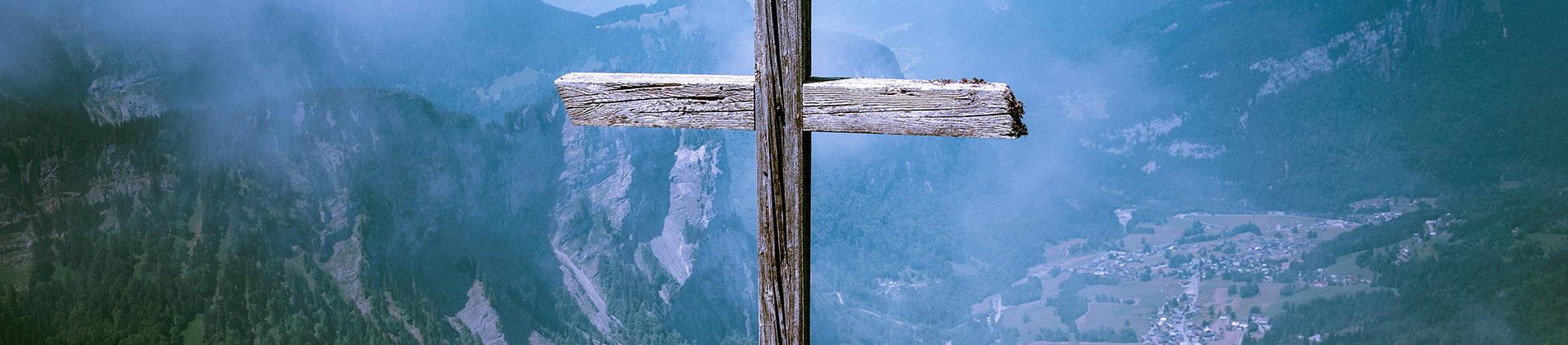 Wooden cross with a mountain range behind