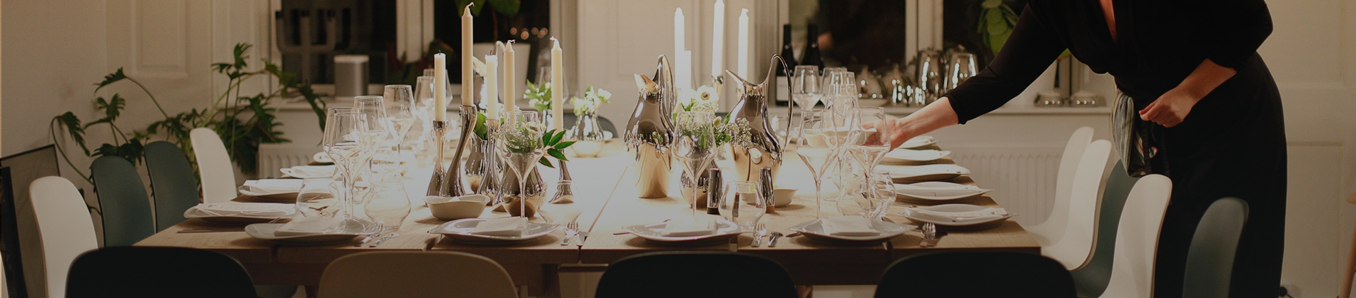 A women setting a large table with plates and glasses A women setting a large table with plates and glasses