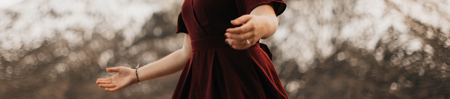 A women in a red dress with her arms open wide A women in a red dress with her arms open wide
