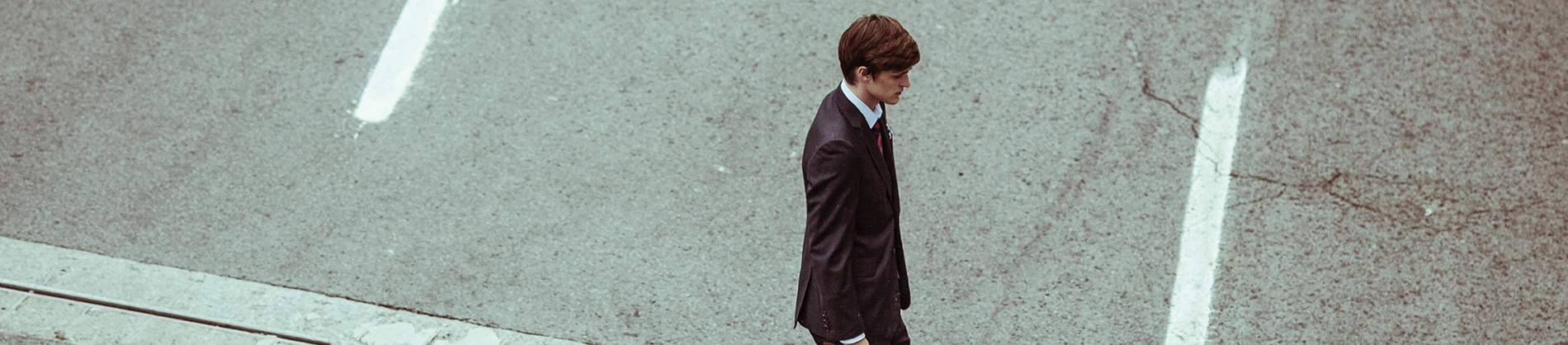 A man dressed in a suit walking across the street